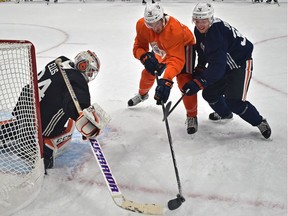 Edmonton Oilers Ben Betker (76) and Jussi Jokinen (36) fight for the puck in front of goalie Nick Ellis during the first day of training camp at Rogers Place in Edmonton on Sept. 15, 2017.