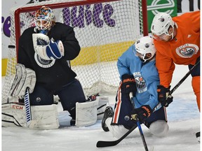 Edmonton Oilers goalie Cam Talbot makes a save as Jujhar Khaira (16) and Adam Larsson (6) get tangled up at practice during training camp at Rogers Place Edmonton, September 21, 2017.