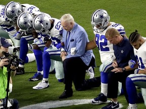 In this Monday, Sept. 25, 2017 file photo, the Dallas Cowboys, led by owner Jerry Jones, center, take a knee prior to the national anthem prior to an NFL football game against the Arizona Cardinals, in Glendale, Ariz. President Donald Trump's clash with the scores of professional football players who knelt during the Star Spangled Banner last weekend has set off a heated debate over proper etiquette during the national anthem.
