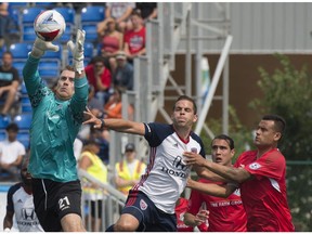 Goalkeeper Tyson Farago of FC Edmonton, left, grabs the ball on a corner kick by the Indy Eleven at Clarke Stadium kicking off the fall NASL season in Edmonton on July 29, 2017.