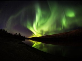 The northern lights shine and reflect on the Clearwater River in Fort McMurray on Sept. 28, 2016.