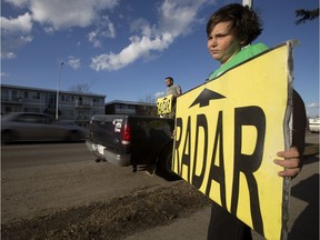 Members of the group Alberta Cash Cows warn motorists about a photo radar location along Whyte Avenue near 98 Street, in Edmonton Saturday April 29, 2017.