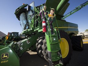 Cali Christman, 7, and her brother Kale Christman, 5, check out a combine during the Meet a Machine event at West Edmonton Mall, in Edmonton Sunday Sept. 10, 2017. Proceeds from the event will go directly towards type one diabetes research.
