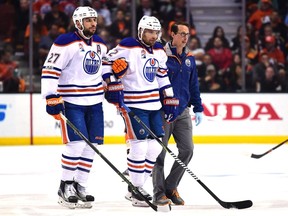 Andrej Sekera #2 of the Edmonton Oilers is helped off the ice by Milan Lucic #27 and a trainer during the first period against the Anaheim Ducks in Game Five of the Western Conference Second Round during the 2017 NHL Stanley Cup Playoffs at Honda Center on May 5, 2017 in Anaheim, California.