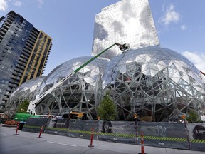 FILE - In this April 27, 2017 file photo, construction continues on three large, glass-covered domes as part of an expansion of the Amazon.com campus in downtown Seattle. Amazon said Thursday, Sept. 7,  that it will spend more than $5 billion to build another headquarters in North America to house as many as 50,000 employees. It plans to stay in its sprawling Seattle headquarters and the new space will be "a full equal" of its current home, said founder and CEO Jeff Bezos.