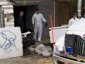 Police investigate the discovery of a body found buried under the cement in a garage behind a home on 96 Street near 118 Avenue on Saturday September 30, 2017 in Edmonton.