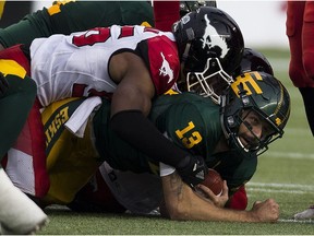 Edmonton Eskimos Mike Reilly (13) is tackled by members of the Calgary Stampeders on Saturday September 9, 2017 in Edmonton.