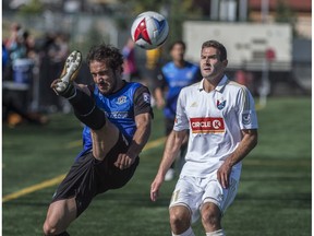 Shawn Nicklaw of the FC Edmonton, clears the ball away from Steven Miller of North Carolina FC at Clark Stadium on September 10, 2017.