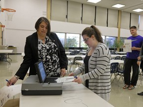 Edmonton Elections liaison Mayja Embleton gives student Hayley Crowe the chance to try casting a ballot Friday at L.Y. Cairns School.
