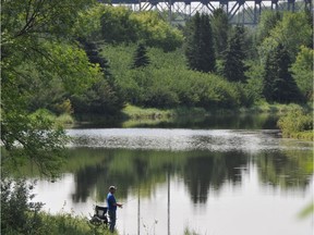 A fisherman stands near the shore of a pond in Hermitage Park in a file photo. The park is one of the popular features in the northeast's Ward 4.