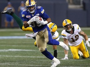 Winnipeg Blue Bombers running back Andrew Harris sheds a pair of Edmonton Eskimos tacklers during CFL action in Winnipeg on Thurs., Aug. 17, 2017.