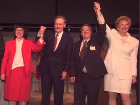 In this historical image from 1996, Anne McLellan, left, then prime minister Jean Chretien, Eric Newell and Pat Black raise their hands after the Declaration of Opportunity was signed by 18 oil players in a launching of the Syncrude 21 expansion project.