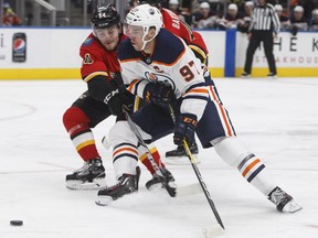 Calgary Flames defenceman Rasmus Andersson (54) battles for the puck with Edmonton Oilers star Connor McDavid (97) during second period NHL preseason action in Edmonton on September 18, 2017.