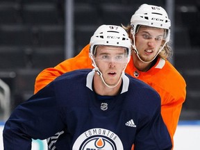 Connor McDavid, in blue, battles against William Lagesson during the Edmonton Oilers training camp at Rogers Place in Edmonton on Friday, Sept. 15, 2017.