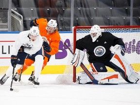 Patrick Russell (white sweater) takes the puck to the net at Oilers training camp in 2017.