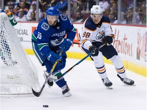 Vancouver Canucks' Alex Biega (55) skates with the puck while being pursued by Edmonton Oilers' Jesse Puljujarvi, of Sweden, during the first period of a preseason NHL hockey game in Vancouver, B.C, on Saturday September 30, 2017.