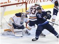 Winnipeg Jets' Matt Hendricks (15) attempts to get the rebound off Edmonton Oilers goaltender Laurent Brossoit (1) as Matthew Benning (83) defends during first period NHL pre-season game action in Winnipeg on Wednesday, September 20, 2017.