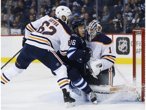 Winnipeg Jets' Shawn Matthias (16) gets up close to Edmonton Oilers goaltender Laurent Brossoit (1) as Eric Gryba (62) defends during second period NHL pre-season game action in Winnipeg on Wednesday, September 20, 2017.