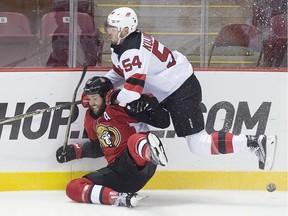 Ottawa Senators Zack Smith takes a hit from New Jersey Devils Ryan Kujawinski, right, during first period NHL preseason hockey action in Summerside, P.E.I., on Monday, Sept. 25, 2017.