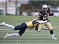 Edmonton Huskies Brandt Burzuk #22 is tackled by Edmonton Wildcats Jayden Dalke  #21 during the Prairie Football Conference junior football game at Clarke Stadium, September 17, 2016.