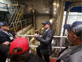 Visitors take a tour led by Peter Delamont (centre), Edmonton Brewery general manager, after a capital investment announcement at Labatt Breweries of Canada's Edmonton Brewery in Edmonton, Alberta on Wednesday, Sept. 20, 2017.