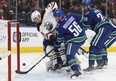 Edmonton's Iiro Pakarinen (26) reaches for a puck behind Vancouver's goaltender Richard Bachman (32) during a preseason NHL game between the Edmonton Oilers and the Vancouver Canucks at Rogers Place in Edmonton, Alberta on Friday, September 22, 2017. Ian Kucerak / Postmedia Photos for stories running Saturday, Sept. 23 edition.