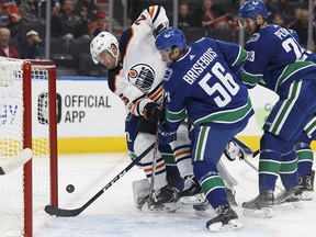 Edmonton's Iiro Pakarinen (26) reaches for a puck behind Vancouver's goaltender Richard Bachman (32) during a preseason NHL game between the Edmonton Oilers and the Vancouver Canucks at Rogers Place in Edmonton, Alberta on Friday, September 22, 2017. Ian Kucerak / Postmedia Photos for stories running Saturday, Sept. 23 edition.