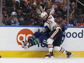 Edmonton's Keegan Lowe (47) checks Vancouver's Jalen Chatfield (63) into the boards during the second period of a preseason NHL game between the Edmonton Oilers and the Vancouver Canucks at Rogers Place in Edmonton, Alberta on Friday, September 22, 2017. Ian Kucerak / Postmedia Photos for stories running Saturday, Sept. 23 edition.