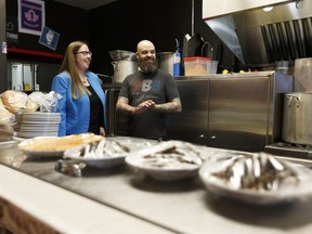 Local Omnivore co-owner Mark Bellows (right) gives Christina Gray, Alberta's Minister of Labour, a tour of the restaurant after announcing the rise in the province's minimum wage to $13.60 in Edmonton, Alberta on Friday, September 29, 2017.