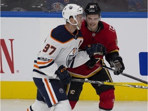 Edmonton Oilers centre Connor McDavid and Calgary Flames defenceman Josh Healey have a chat after McDavid hit Healey during preseason NHL action on September 18, 2017 in Edmonton.