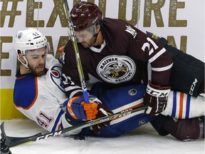 Edmonton Oiler rookie Evan Polei, left, is checked by MacEwan-NAIT All-Stars Brett Njaa during third period action at the 2017 Rookie Game held at Rogers Place in Edmonton on September 13, 2017.