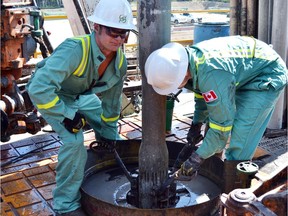 Roughnecks work at an Encana drilling site near Wembley.