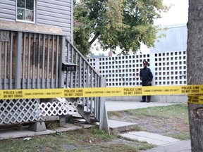A police officer stands watch outside of 11119 94 St. in Edmonton on Monday, Sept. 18, 2017, after a man was found at the residence by northwest division police officers. This comes after Nexhmi (Nick) Nuhi, 76, was fatally shot through the door at the same multi-unit residence on Wednesday, Sept. 13, 2017.