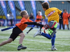 Two players take part in the CFL/NFL Flag Football initiative at Commonwealth Stadium on Saturday, Sept. 24, 2017.