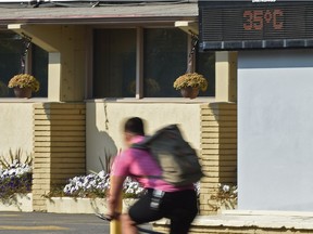 A temperature record was broken Thursday as a cyclist rides by a temperture sign reading 35º C along 83 Ave. and 104 St. in Edmonton, September 7, 2017.