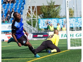 FC Edmonton midfielder Sainey Nyassi, left, runs past the net after scoring on Indy Eleven goalkeeper Jon Busch in North American Soccer League play at Clarke Stadium in Edmonton on Sunday, Sept. 17, 2017.