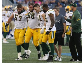 Edmonton Eskimos offensive lineman Jean-Simon Roy is helped off the field during CFL action against the Winnipeg Blue Bombers in Winnipeg on Thurs., Aug. 17, 2017.