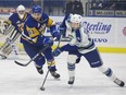 Saskatoon Blades forward Josh Paterson fights for the puck against Swift Current Broncos forward Aleksi Heponiemi at SaskTel Centre in Saskatoon, SK on Friday, October 6, 2017.