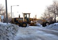 A worker with a private snow removal company contracted by the city of Edmonton grates a road near 108 St. and 137 Ave.