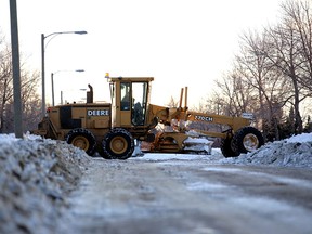 A worker with a private snow removal company contracted by the city of Edmonton grates a road near 108 St. and 137 Ave.