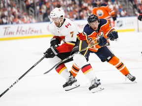 Kailer Yamamoto #56 of the Edmonton Oilers, playing in his first NHL game, skates against T.J. Brodie #7 of the Calgary Flames at Rogers Place on October 4, 2017 in Edmonton, Canada.