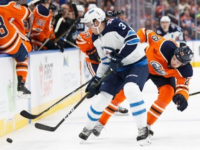 Leon Draisaitl #29 of the Edmonton Oilers battles against Tucker Poolman #3 of the Winnipeg Jets at Rogers Place on October 9, 2017 in Edmonton.