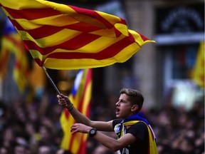 A boy waves a Catalan flag as people celebrate at the Sant Jaume square in Barcelona on October 27, 2017.  Catalonia's parliament voted to declare independence from Spain and proclaim a republic, just as Madrid is poised to impose direct rule on the region to stop it in its tracks. A motion declaring independence was approved with 70 votes in favour, 10 against and two abstentions, with Catalan opposition MPs walking out of the 135-seat chamber before the vote in protest at a declaration unlikely to be given official recognition.