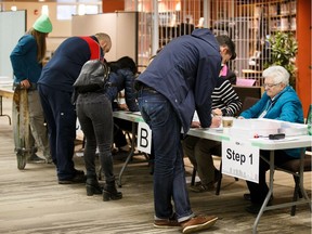 Edmonton incumbent mayor Don Iveson, right, registers to vote on election day at McKernan Baptist Church in Edmonton on Monday, Oct. 16, 2017.