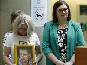 Petra Schulz (left) holds a photograph of her son Danny, who died from a fentanyl overdose, at the Royal Alexandra Hospital in Edmonton on October 18, 2017 where Alberta Associate Minister of Health Brandy Payne (right) announced that the first cities in Alberta to have supervised consumption services for people at risk of overdosing from drugs will be Edmonton and Lethbridge.