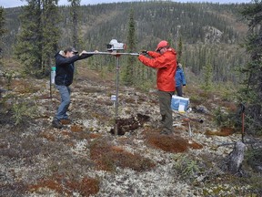 Duane Froese (right) and graduate student Joe Young drill a permafrost core along the Dempster Highway, north of Dawson City, Yukon.