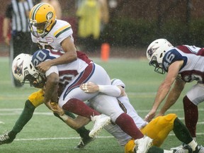 Montreal Alouettes' Tyrell Sutton (20) is tackled by Edmonton Eskimos' defenders during first half CFL football action in Montreal, Monday, October 9, 2017.