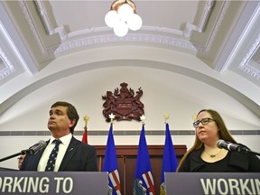 Reporters pressed Labour Minister Christina Gray and Agriculture and Forestry Minister Oneil Carlier on the technical working group reports on how occupational health and safety rules may apply to farms and ranches, at the Alberta legislature in Edmonton, Oct. 26, 2017.