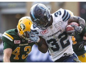 Toronto Argonauts running back James Wilder Jr. (right) is tackled by Edmonton Eskimos defensive back Neil King during the first half of CFL football action in Toronto on Saturday, September 16, 2017.