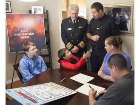Fire Chief Ken Block of Edmonton Fire Rescue Services, standing left, joined fire prevention officer Martin Landry at the St. Pierre family home  as they planned and practised a fire escape plan and demonstrated the importance of having a second way out, on Oct. 4, 2017.